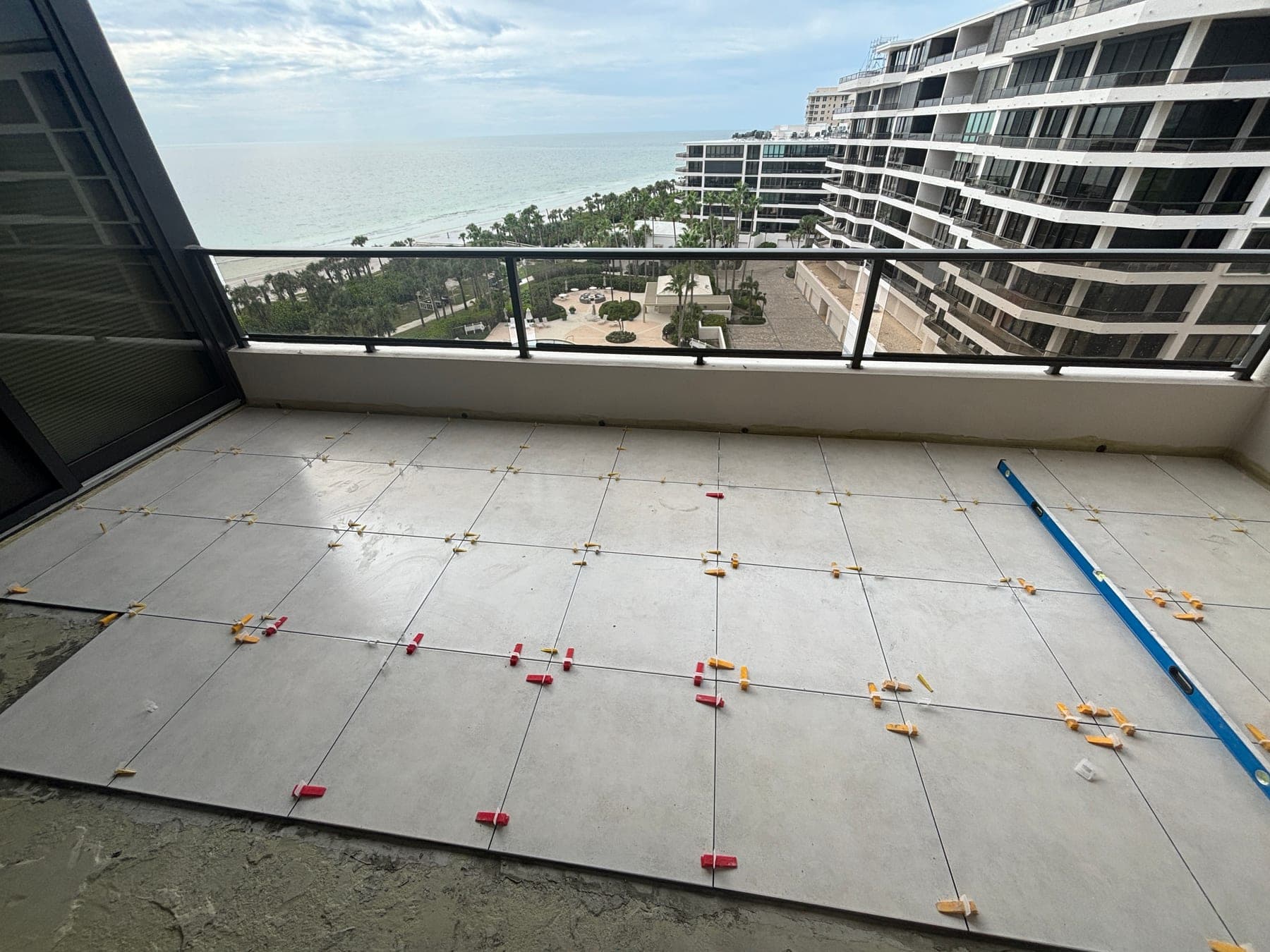 Large rectangular balcony tile being aligned with leveling clips