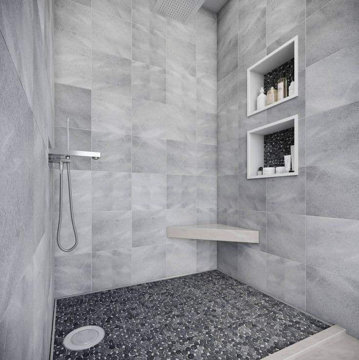 Walk-in tiled shower with storage niches, corner bench, and mosaic floor